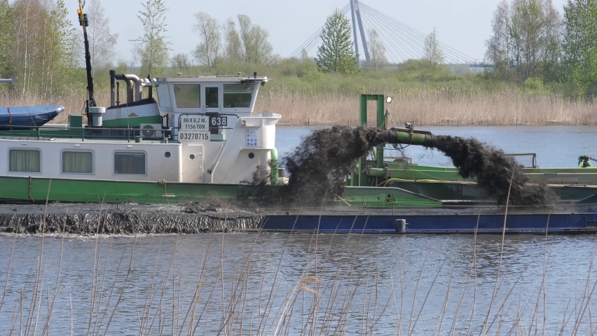 Dredging ship dredges off mud from river bottom to improve the fairway, river IJssel in the Netherlands