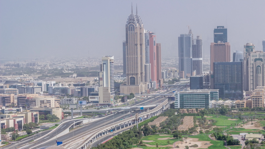 Aerial view of Sheikh Zayed Road in Dubai Internet City and barsha area timelapse. Skyscrapers and traffic on a highway with metro station