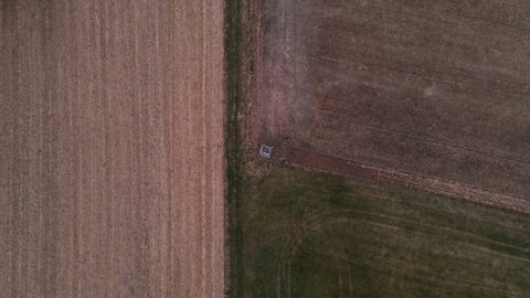 A hunter's deer stand in the middle of green and brown fields in Germany. Aerial high angle view