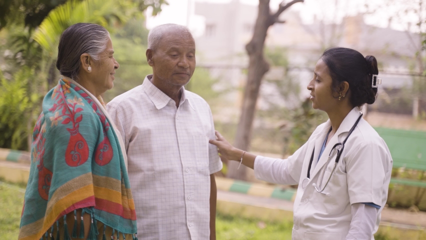 Doctor advising senior couple about elderly healthcare tips while at hospital park - concpet of professional occupation, expertise and counseling. | Shutterstock HD Video #1089448905