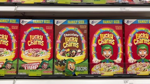 Alameda, CA - April 18, 2022: 4K HD video zooming in on grocery store shelf with General Mills brand cereals boxes of Lucky Charms. Saint Patrick's themed, chocolate and regular.
