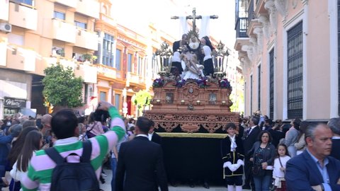 Huelva, Spain - April 14, 2022: Throne or platform Solemn of the Brotherhood of the Holy Cross in procession by the narrow streets of the city