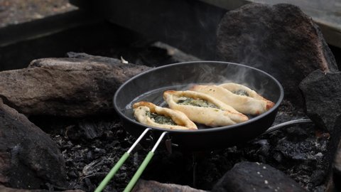 Heating up Turkish Pide Pies in Frying Pan, Outdoor Cooking Concept, Close Up