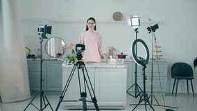Young woman is filming a cooking vlog in a professional studio