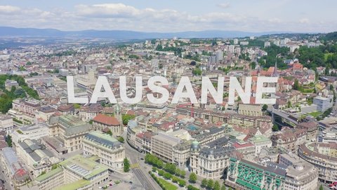 Inscription on video. Lausanne, Switzerland. Flight over the central part of the city. La Cite is a district historical centre. Glitch effect text, Aerial View, Departure of the camera