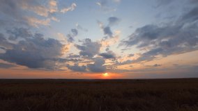 Fantastic sunset over farmland in summer. Location place agrarian region Ukraine, Europe. Fast flying clouds in sky. Time lapse footage, cinematic clip. Filmed in Full HD 1080p video. Beauty earth.