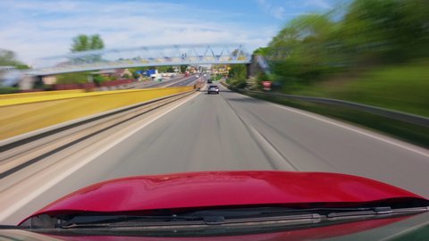 Timelapse red car driving on the road.  Cars go on high-speed highway. Speedy car driving the highway with a lot of traffic, overtaking other vehicles 