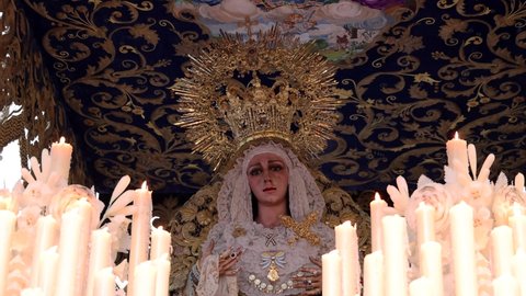 Huelva, Spain - April 13, 2022: Procession of the Paso de Semana Santa (Platform or Throne) of the Brotherhood of the Virgin of Victory while a woman sing a Saeta