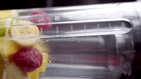 Making a smoothie in a blender from different fruits with ice, slow motion video 4K video, vertical video