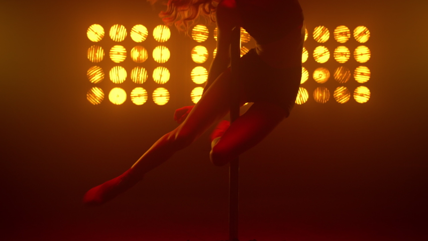 Woman body spinning on pylon nightclub. Seductive girl performing poledance emotionally in strip club spotlight. blonde dancing erotic movements illuminated soft lamps. Party concept.