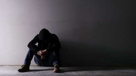 Asian troubled man wearing a hood in an empty room