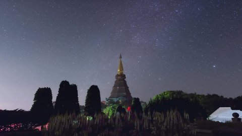 Time Lapse 4K of The Starry night moving over a sacred temple at Doi Inthanon National Park, Chiang Mai, Thailand. Night lapse from night to day.