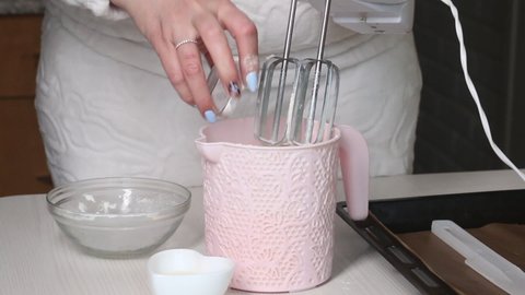 A woman adds ingredients to a container, makes dough. The ingredients for making the cake are laid out on the table. Cooking biscuit cake Dairy girl.