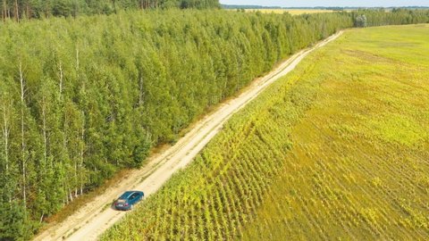 Gomel, Belarus - August 30, 2021: Elevated Aerial View Of Blue Lada Vesta Car Vehicle Automobile In Fast Drive Motion On Countryside Country Road Through Summer Corn Maize Green Fields. Agricultural