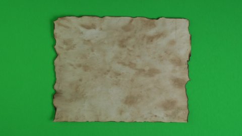Yellow grunge ancient parchment paper on green background for transparency, key color and chroma key. Old witch book empty page from above. Medieval manuscripts page.