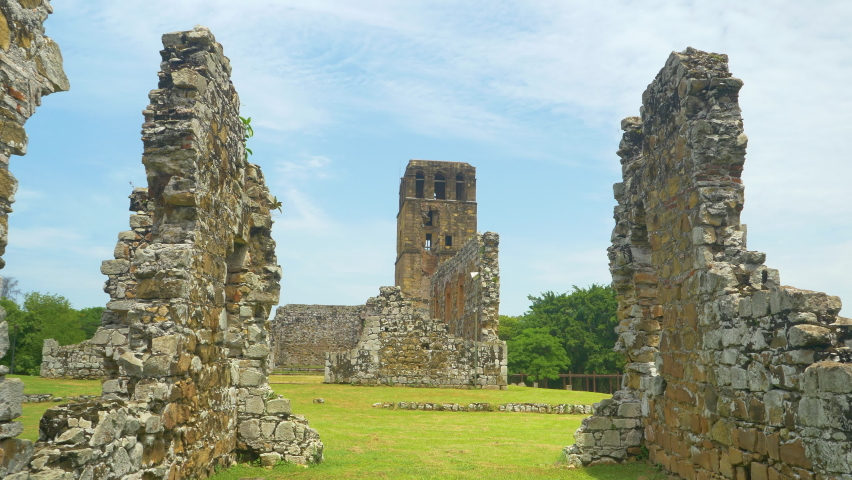 CLOSE UP: Ancient cathedral towers above the decaying buildings of Old Panama. Scenic shot of the decaying ruins of Panama Viejo surrounded by lush tropical vegetation. UNESCO heritage site in Panama. Royalty-Free Stock Footage #1089486177