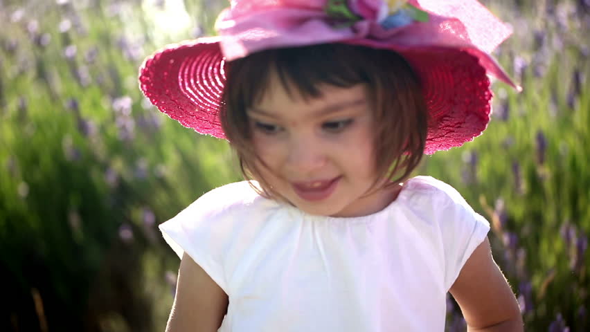 Portrait of a baby girl in a lavender field at sunset. Smiley face