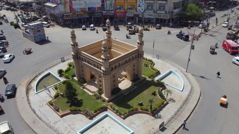 Aerial rotation shot of a famous roundabout called Char Minar in Karachi as traffic circles it. Karachi, Pakistan. 25th March 2021