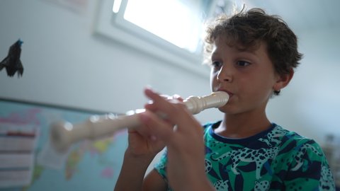 Young musician playing flute rehearsing with musical instrument