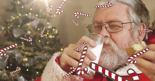 Animation of candy canes falling over santa drinking milk at christmas. world milk day and christmas concept digitally generated video.