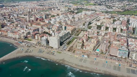 Aerial drone footage of the beautiful beach front of the coastal town of  Fuengirola in Malaga Spain Costa Del Sol, showing the sandy beach, hotels and apartments on a sunny day in the summer time