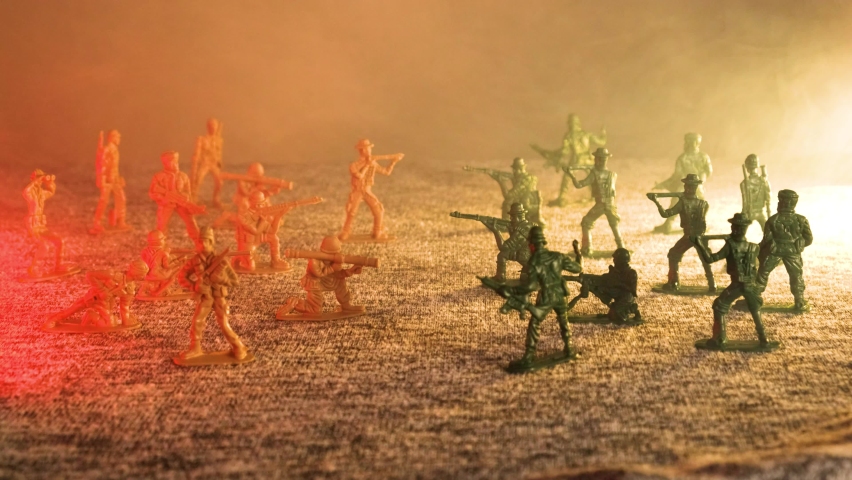 Plastic toy soldiers on the battlefield are falling in smoke. The concept of war and death on the battlefield