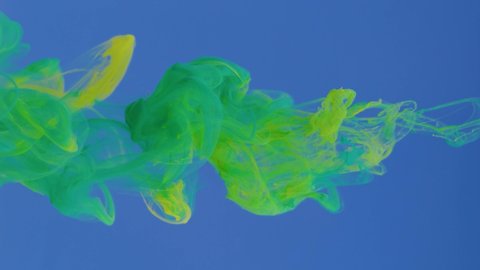 Green and yellow paint drops in water on a blue background, abstract and beautiful wave of ink. 8K downscale, slow motion. Filmed on cinema camera, 4K.