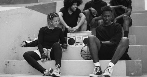 Group of young african people listening music from vintage boombox stereo outdoor 