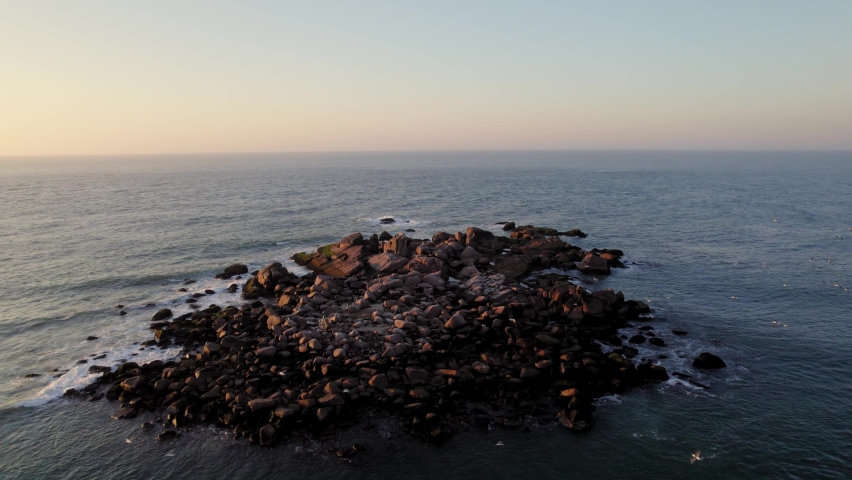 Rock island and seagulls at sunrise