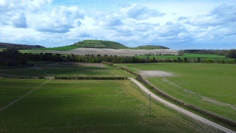 Drone flying fast over fields and farmland in Wiltshire nature, England