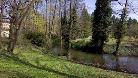 Riverbed with a flowing river among the trees in a park in the city of Olomouc, on a sunny spring day Czech Republic