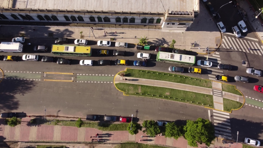 Aerial top view over busy Buenos Aires avenue with biker on bike path and urban car and bus traffic, Argentine