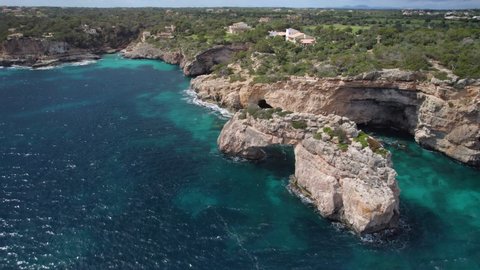 Es Pontas Natural arch, and eroded shoreline, Mallorca rocky coastline, drone view