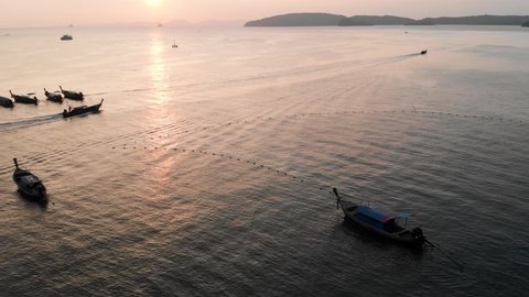 Upwards Tracking Drone Shot Of A Long-tail Boat During Sunset Near Ao Nang Beach With The Sun Setting In The Background. Krabi, Thailand