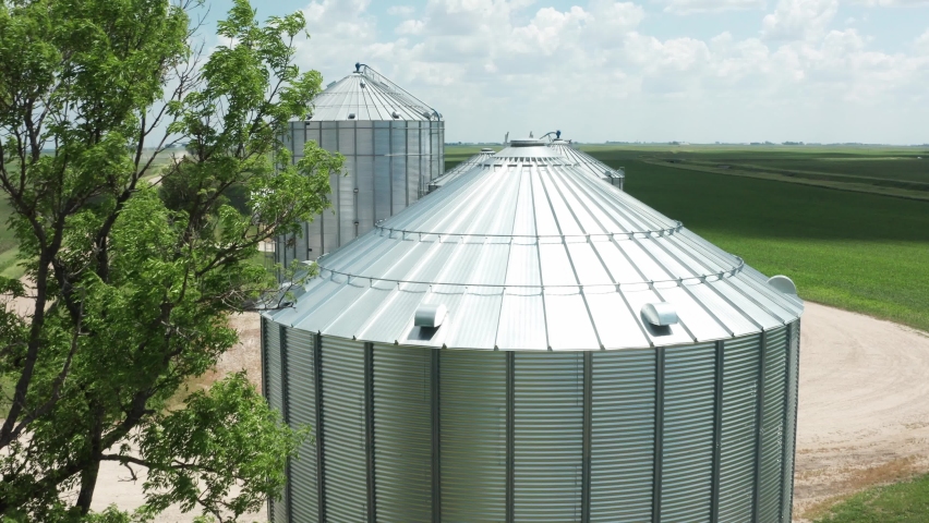 Aerial, agricultural grain bin silos on a rural farm field in the United States