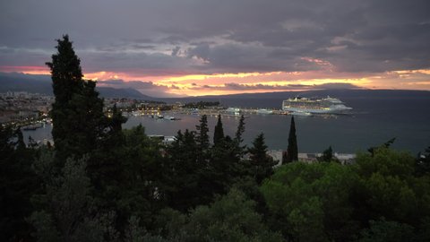 SPLIT, CROATIA - AUGUST 27, 2021: Rainy sunrise and large cruise liner in Split, Croatia. 4K, Audio. Wide shot