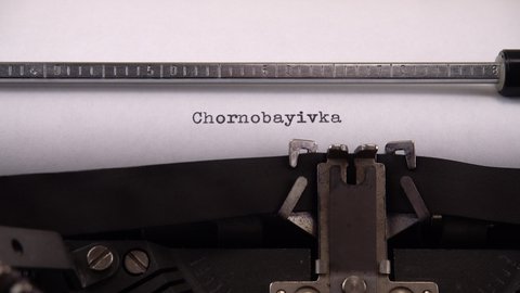 Typing name of village in the Kherson region of Ukraine "Chornobayivka, Ukraine" on retro typewriter.