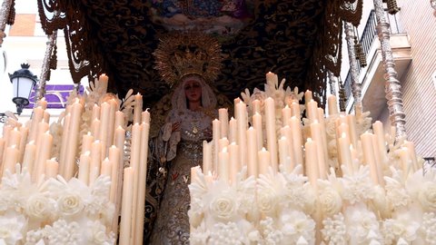 Huelva, Spain - April 13, 2022: Procession of the Paso de Semana Santa (Platform or Throne) of the Brotherhood of the Virgin of Victory while a woman sing a Saeta