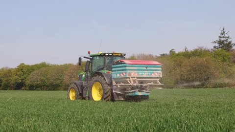 Perry Green, Much Hadham, Hertfordshire. UK. April 22nd 2022 Farmer using a fertiliser spreader on a tractor in a field.