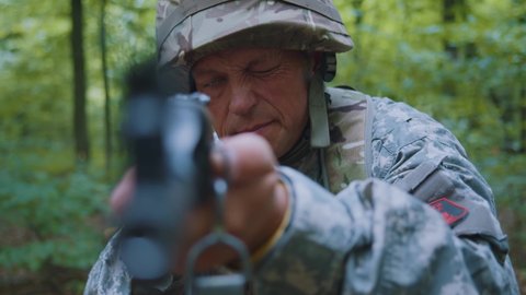 Portrait man soldiers holding machine gun forward to attack enemy in forest. Machine gun barrel look at camera.
