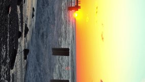 Storm waves crash against old reinforced concrete pillars on the beach against the background of a colorful and red orange sunset, a storm at sea. vertical video, slow motion - Powered by Shutterstock - Get 15% off with code: PIKWIZARD15