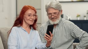 A senior couple in their 60s make an online purchase by choosing a product using a smartphone.Search Marketing, Data Freelance, Education Job, Smart Typing, Creative Finance