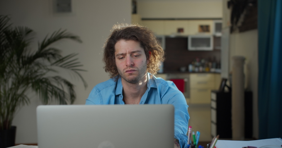 Thoughtful serious young jewish man writer sit at home office desk with laptop thinking of inspiration search problem solution ideas lost in thoughts concept dreaming looking away Royalty-Free Stock Footage #1089516951