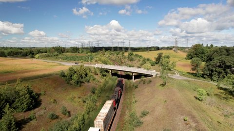 Scarborough , Ontario , Canada - 09 06 2021: Freight Train Carrying Vital COVID supplies Crossing the Country under road bridge through green landscape with bright blue sky on a clear day