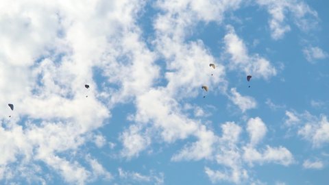 Parachutes in front of the clouds at Manali in Himachal Pradesh, India. Tourists enjoying paragliding experience at Manali. People enjoying the paragliding experience at Manali 