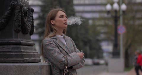 Woman smoking electronic cigarette, vape in the city