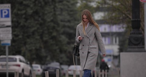 Woman smoking electronic cigarette, vape walking in the city