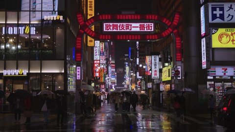 Tokyo , Japan - 04 09 2022: Static shot of Kabuki Cho street at night in the rain 4k