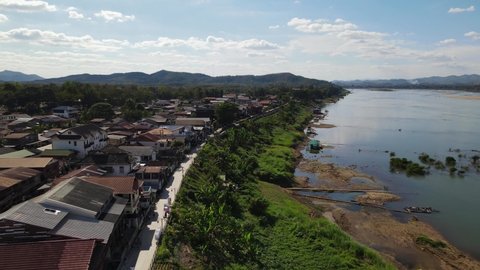 Aerial reverse footage of the Walking Street in Chiang Khan, Loei in Thailand, also revealing Laos with Mekong River.