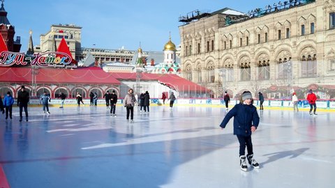 Moscow, Russia, Red Square, GUM skating rink, 14.02.2022. Ice skating rink on Red Square in Moscow. People are skating on an ice skating rink outdoors. High quality 4k footage